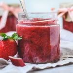 Hjemmelavet jordbær rabarber marmelade i glas med sløjfe om.