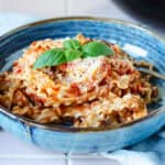 Lækker pasta pomodoro - pasta med tomatsovs toppet med revet parmesan og frisk basilikum, serveret i smuk blå skål
