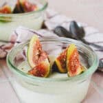 Nærbillede af panna cotta med figenblade og friske figner i små glas – silkeblød italiensk dessert.