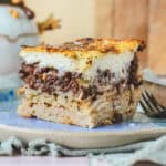 Pastitsio – græsk lasagne – serveret på blå keramik. Tydelige lag af pasta, kød og bechamel. Traditionel græsk pastaret